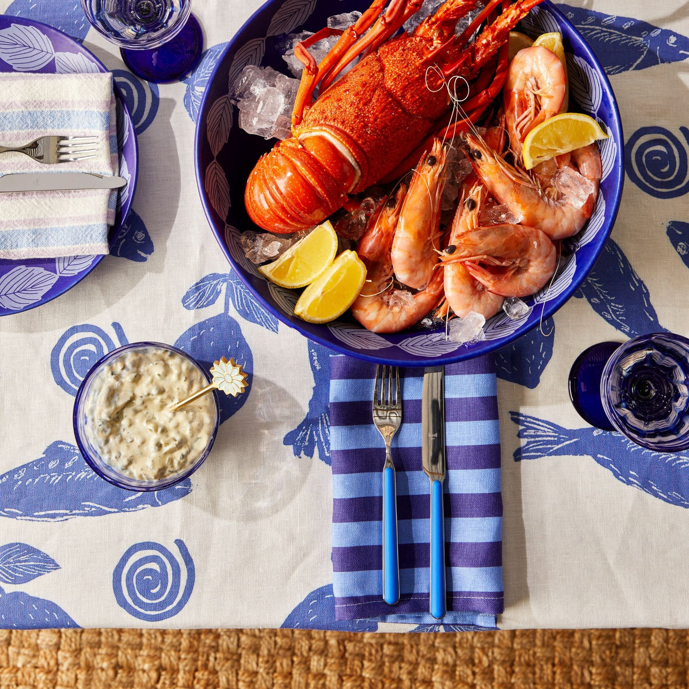 top view of seafood placed on the table with bonnie and beil linen table cloth with blue sardines design print