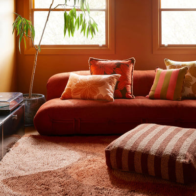 Living room with sofa and floral cushion and Boucle Stripe Chocolate Pouffe