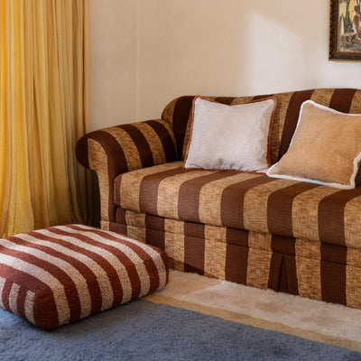 Brown stripe sofa with cream & white cushion and Boucle Stripe Chocolate Pouffe