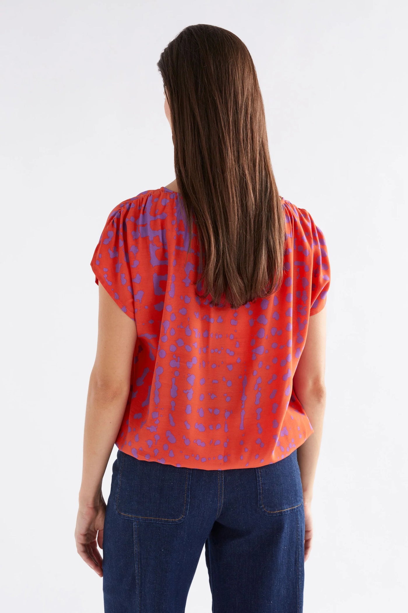 Woman facing the back wearing Elk The label filma top aero print and dark blur denim pants