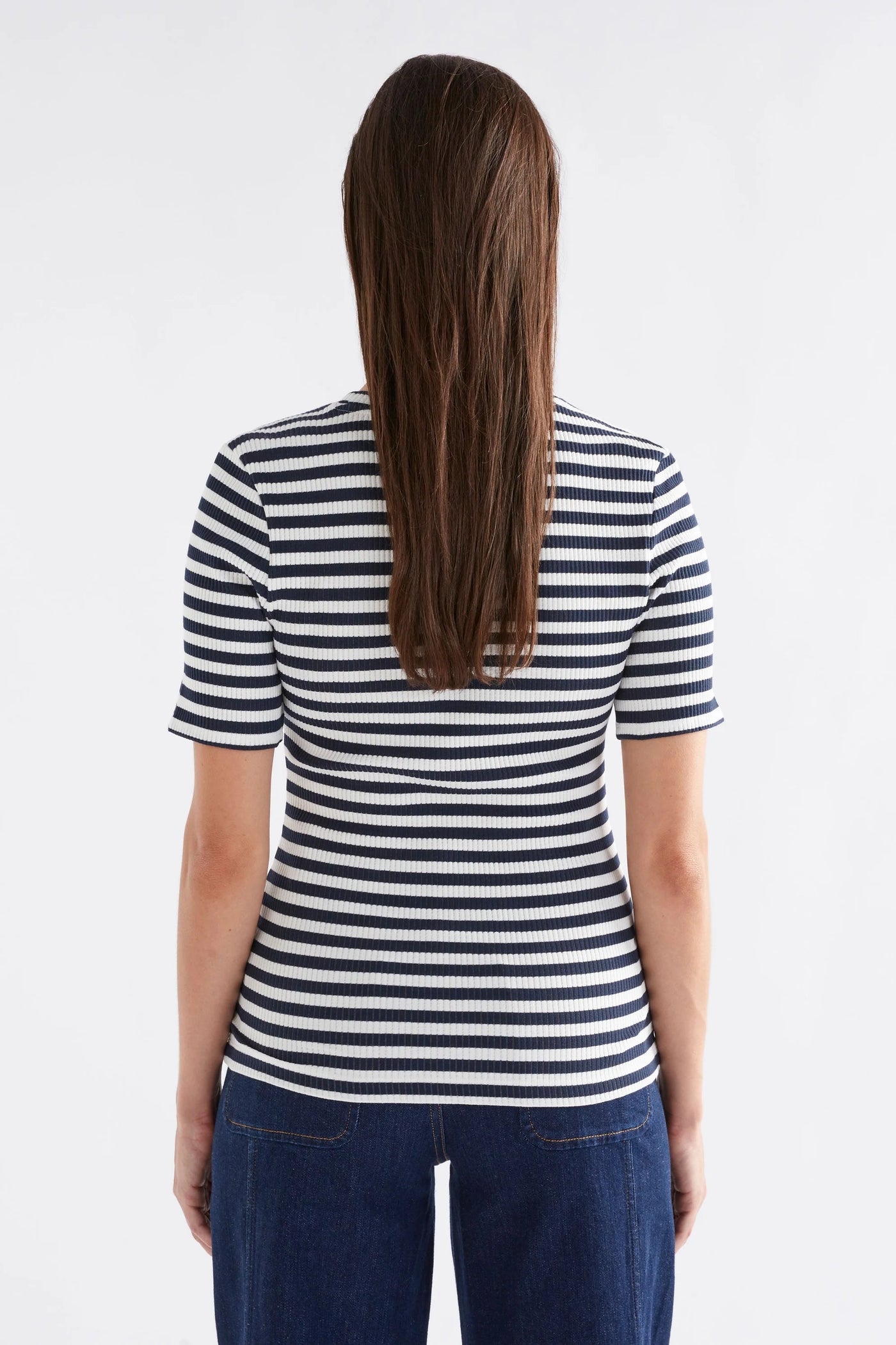 woman facing the back wearing kullan ribbed shirt white ink stripe and dark blue denim pants