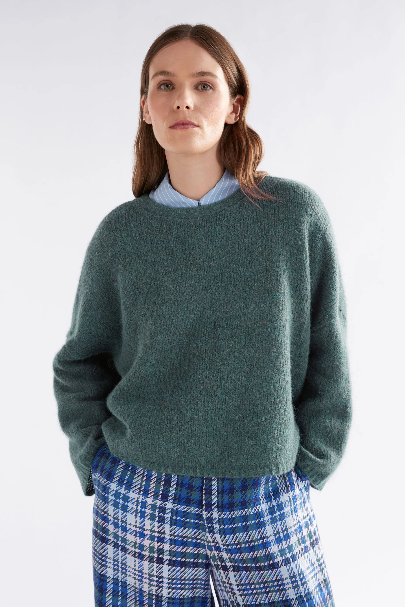 Woman wearing Agna Luna Sweater in Sea Moss and Blue plaid bottoms