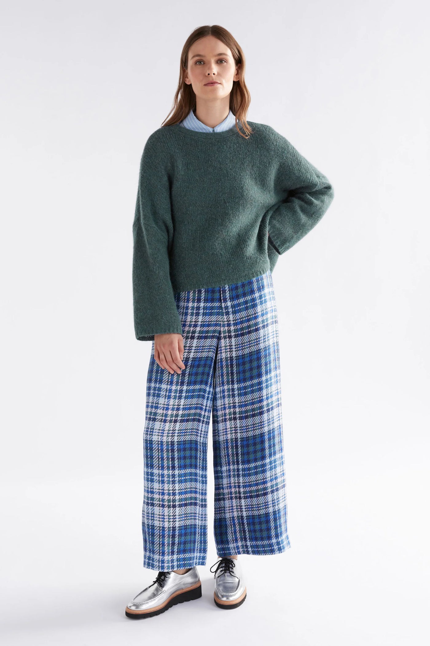 Woman wearing Agna Luna Sweater in Sea Moss and Blue plaid bottoms