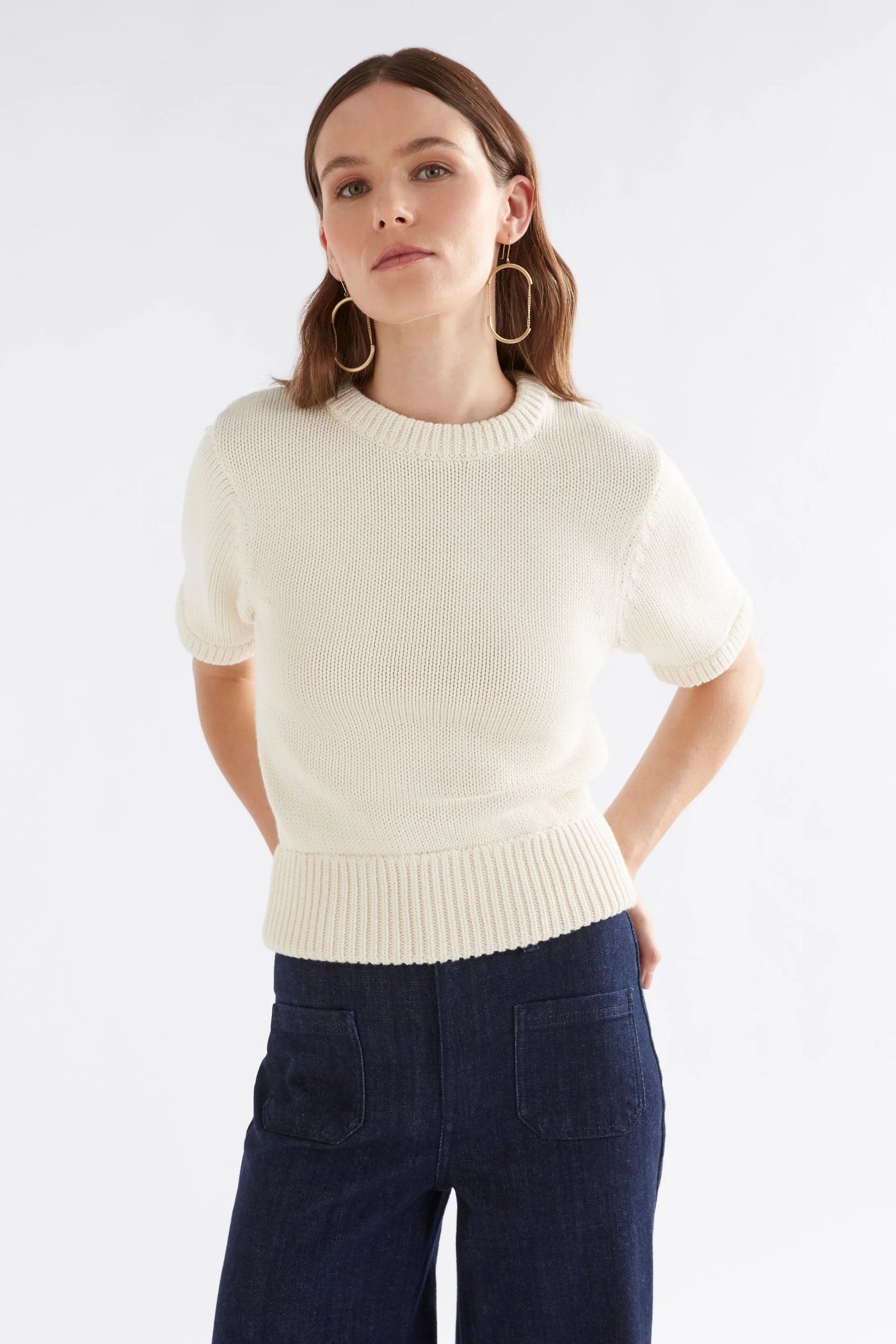 Woman wearing Luft Knit Top in White and Dark Blue Denim pants