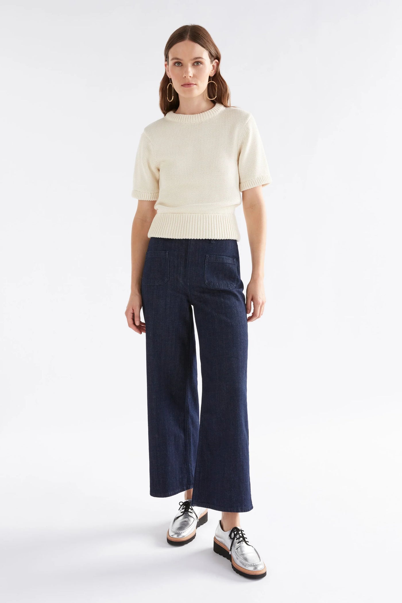 Woman wearing Luft Knit Top in White and Dark Blue Denim pants