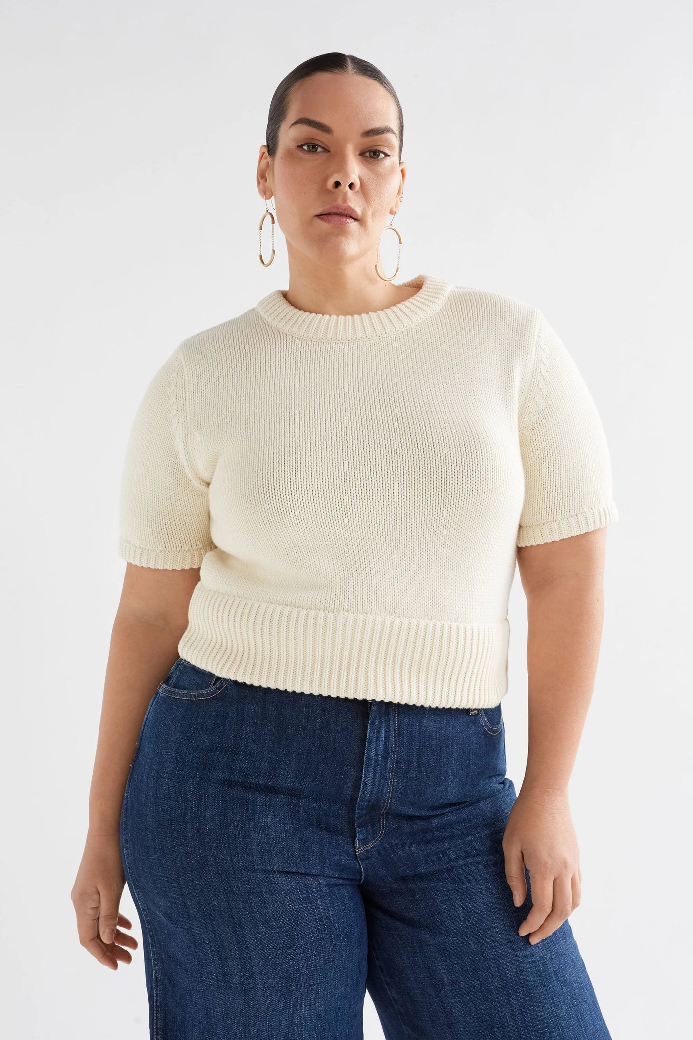 Plus Size Woman wearing Luft Knit Top in White and Dark Blue Denim pants