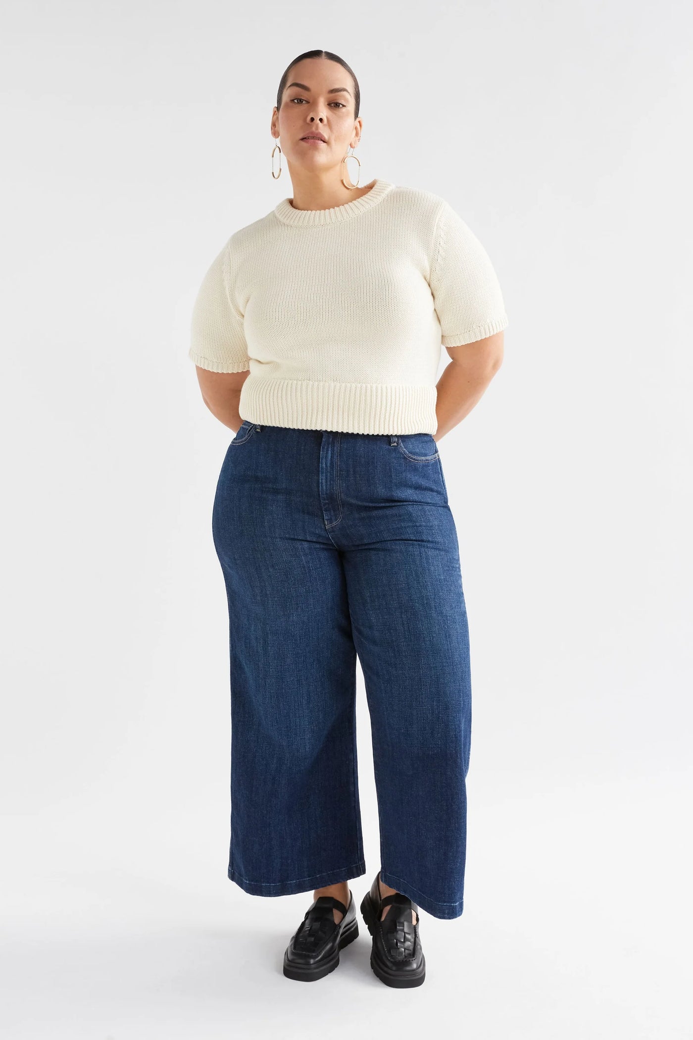 Plus Size Woman wearing Luft Knit Top in White and Dark Blue Denim pants