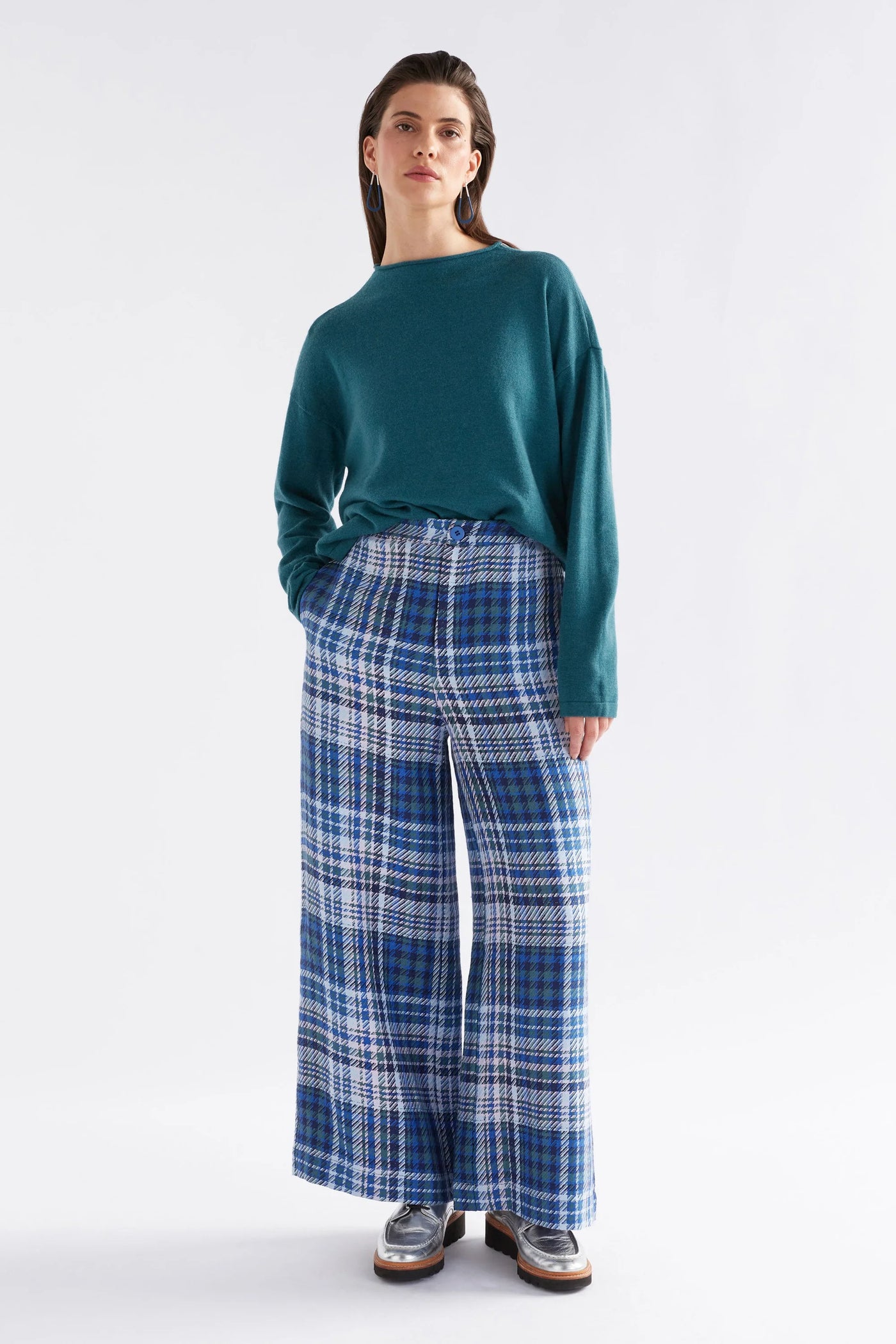 Woman wearing Pirata Sweater in Sea Moss and Blue plaid bottoms