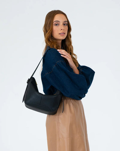 Woman in denim top and brown skirt using Barton Shoulder Bag - Black