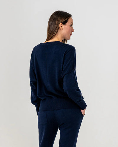 Woman wearing Lucy Knit in Navy and Track pants in navy back view