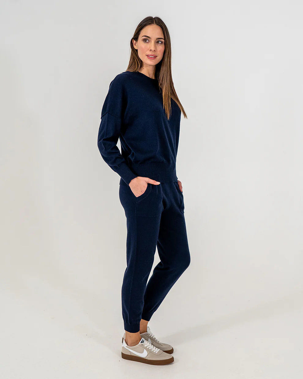 Woman wearing Lucy Knit in Navy and Track pants in navy side view