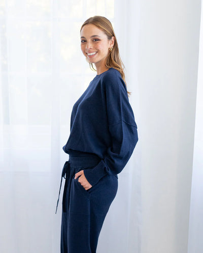 Woman wearing Lucy Knit in Navy and Track pants in navy side view