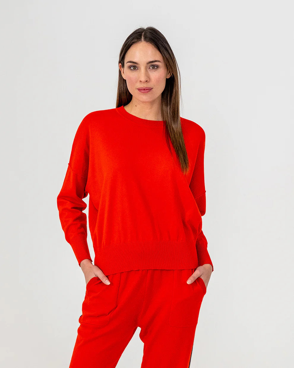 Woman wearing Lucy Knit in Poppy and Track pants in Poppy colour