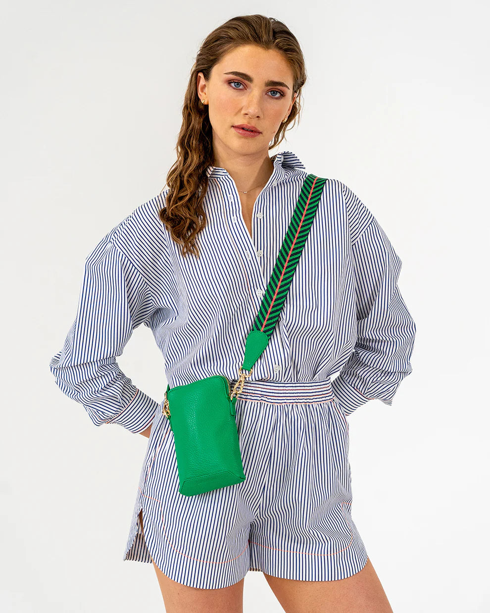 Woman wearing a cross body bag pf Elms and King Sullivan Phone Bag in Green