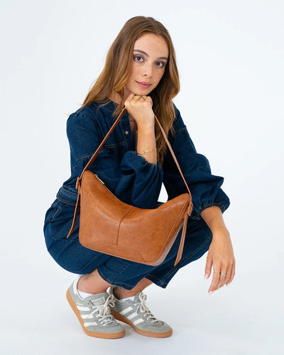 Woman holding the Barton Shoulder Bag - Tan Pebble