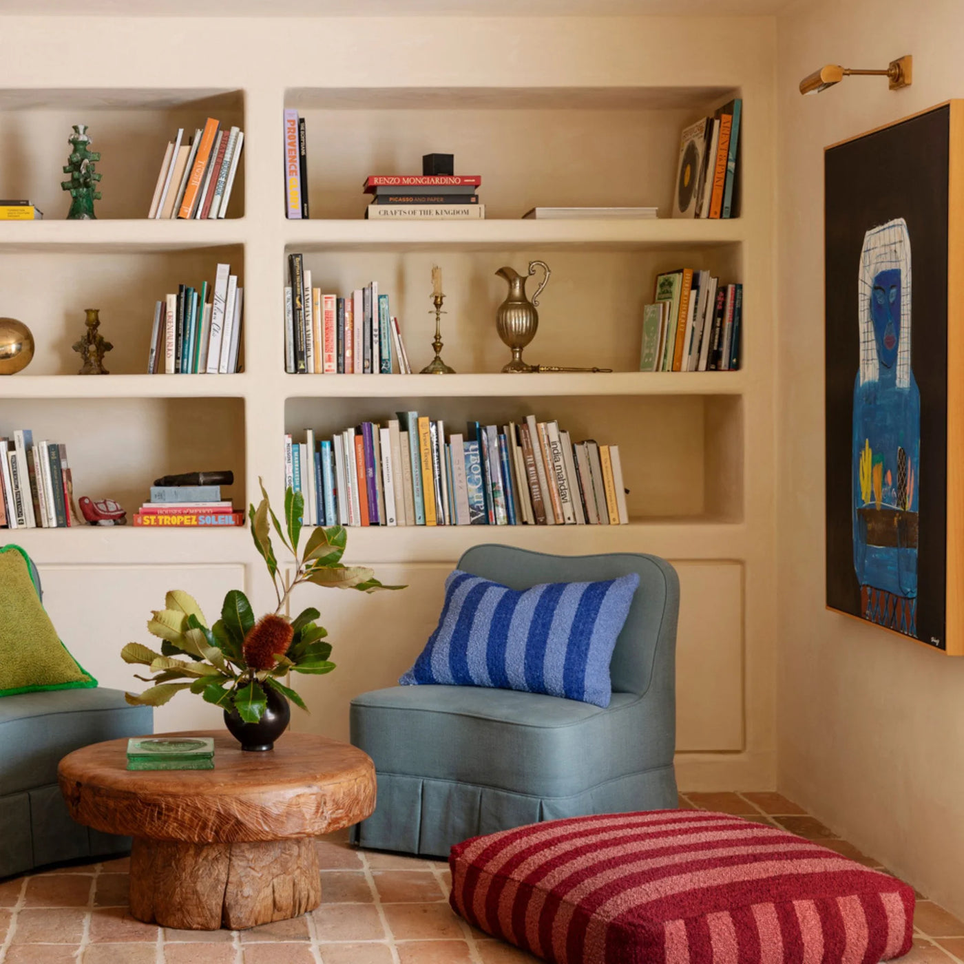 chair with blue strip cushion and Boucle Stripe Burgundy Pouffe beside bookshelve