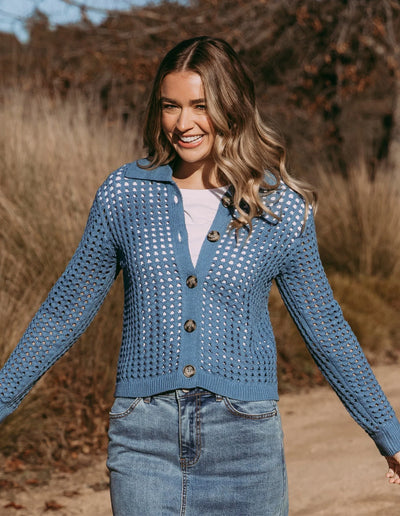 woman wearing Clover Knit Cardi in Coronet Blue, white top and denim skirt