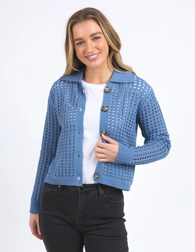 Portrait of woman wearing Clover Knit Cardi in Coronet Blue, white top and black pants