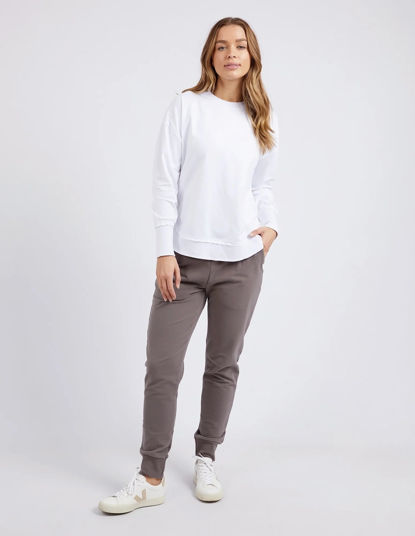 woman wearing foxwood farrah long sleeve white and brown pants and white shoes