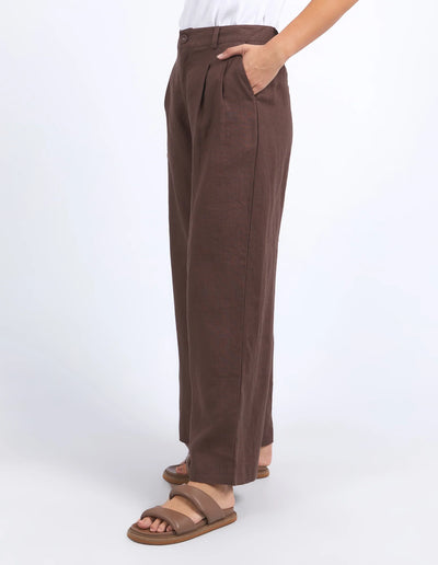 woman wearing white sleeveless top and foxwood pierra pants in chocolate colour