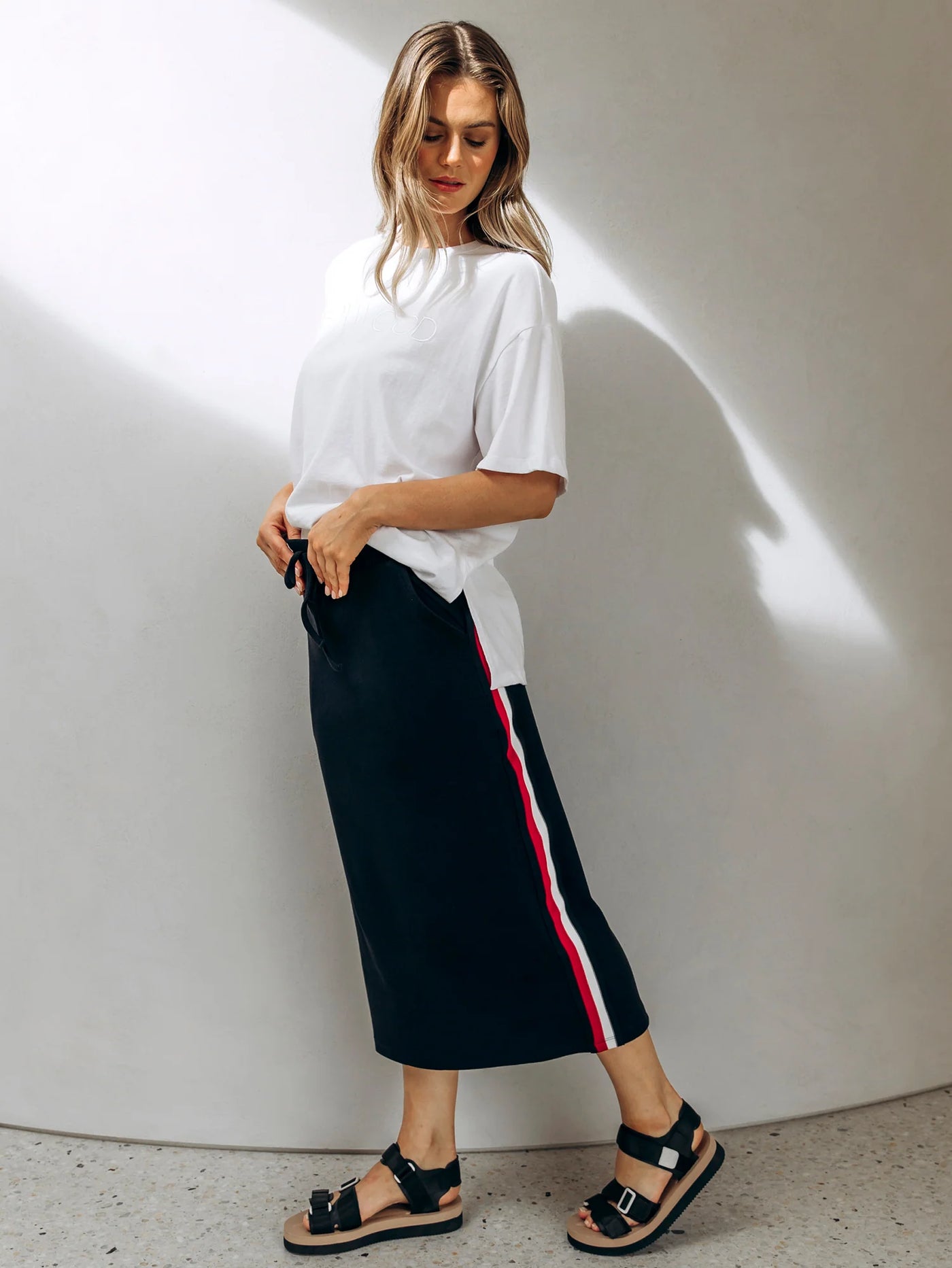 woman wearing white shirt, foxwood navy stabilize skirt and black sandals