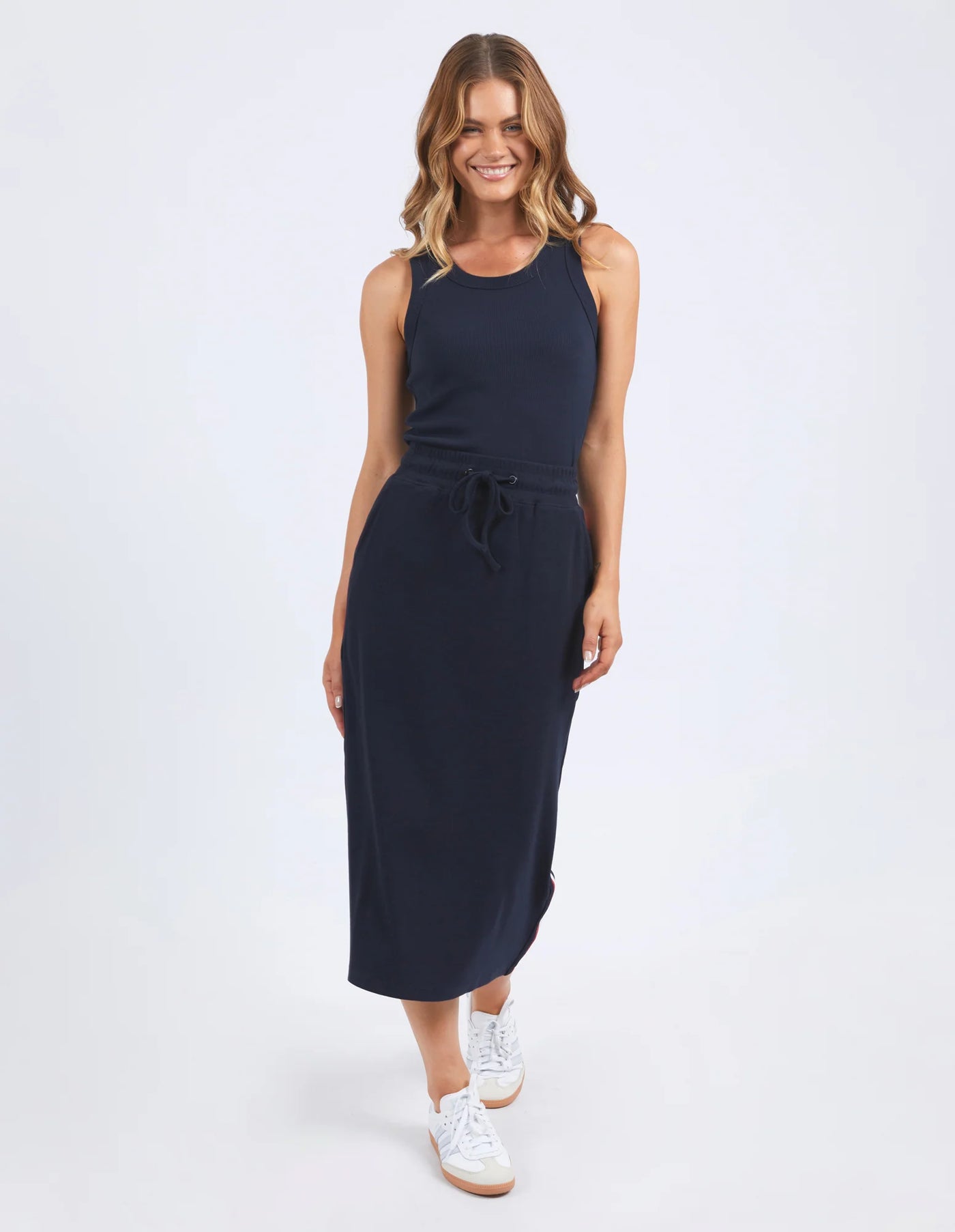 woman wearing sleeveless top, foxwood navy stabilize skirt