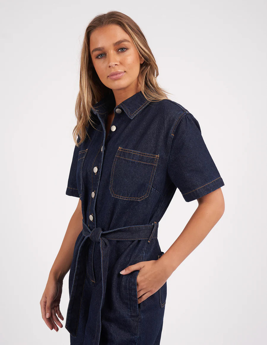 Woman wearing Lorena Jumpsuit Indigo Denim with hand in the Jumpsuit pocket