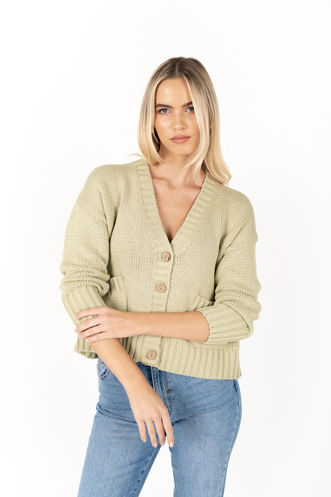 Woman wearing Citta Cardi in Pistachio front view and denim pants