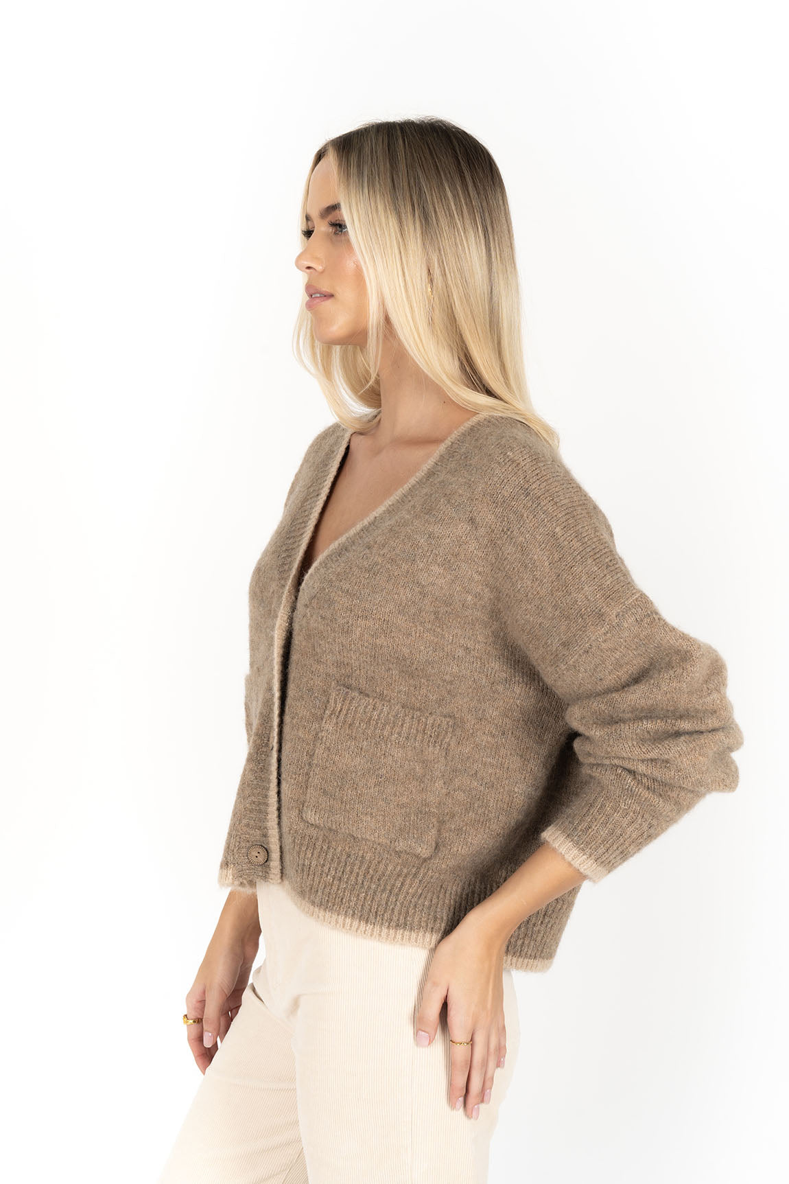 Woman wearing Romi Cardi in Haze and Cream and Pants in cream side view