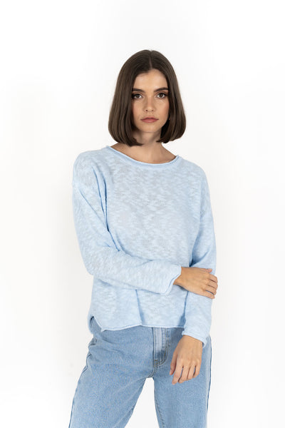 Woman wearing Humidity Lifestyle Sofia Sweater in Powder Blue and denim pants