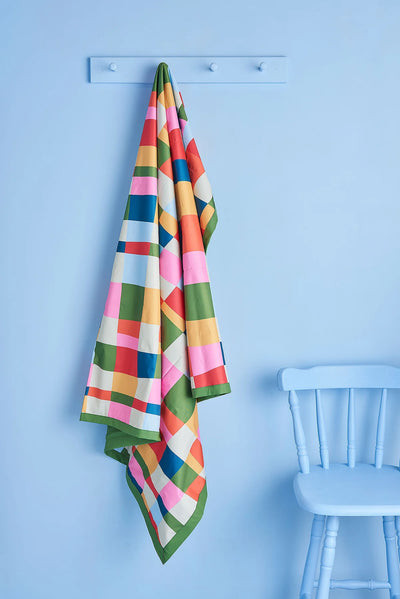 Picnic Mat Rainbow Weave hooked in the blue wall with blue chair