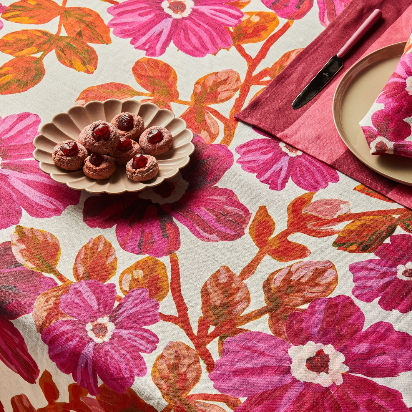 cookies on the plate placed on table with flower print table cloth with bonnie and neil big stripe cerise napkins