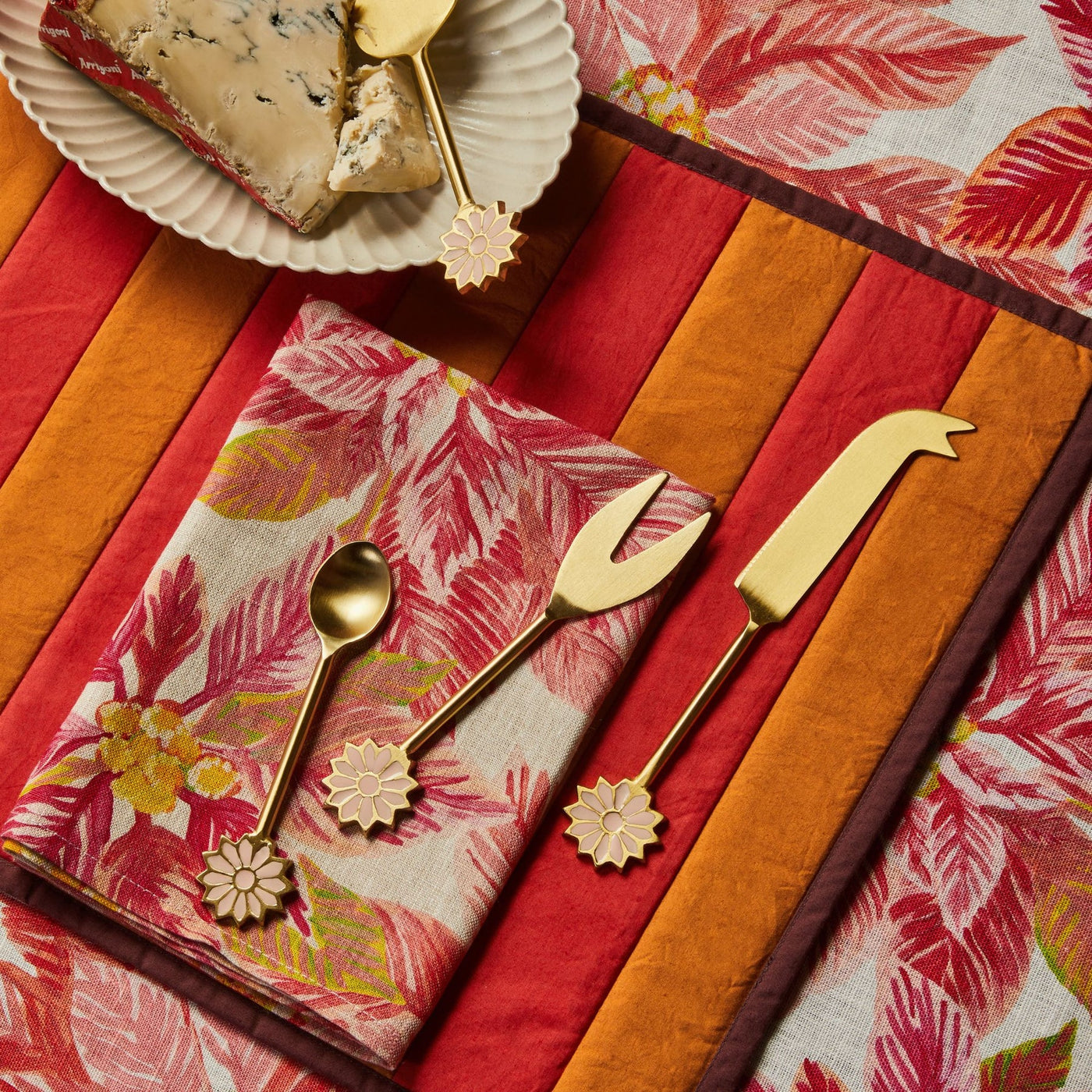 table with bonnie and neil poinsettia red round tablecloth and folded napkin and some tableware