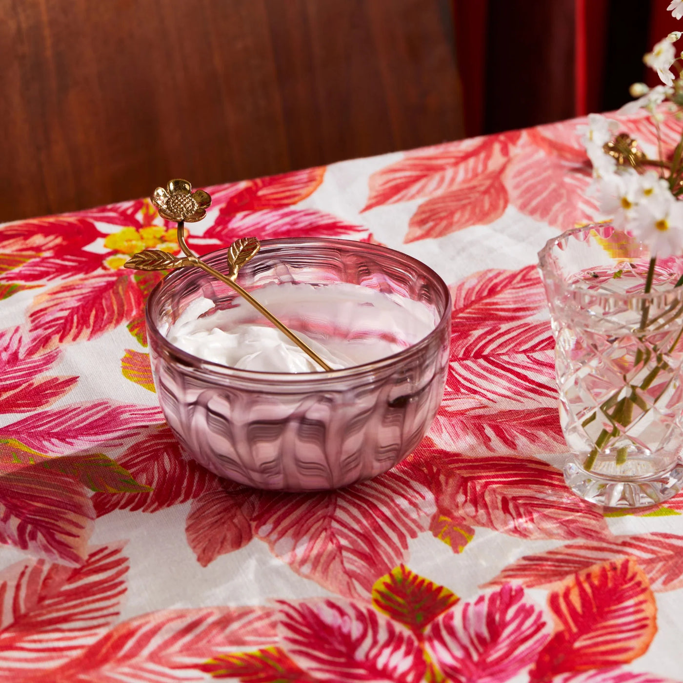 cream inside the small bowl placed on the table with bonnie and neil poinsettia red tablecloth