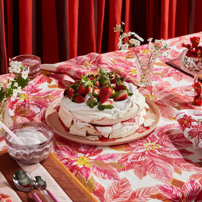 strawberry cake placed on the table with bonnie and neil poinsettia red tablecloth