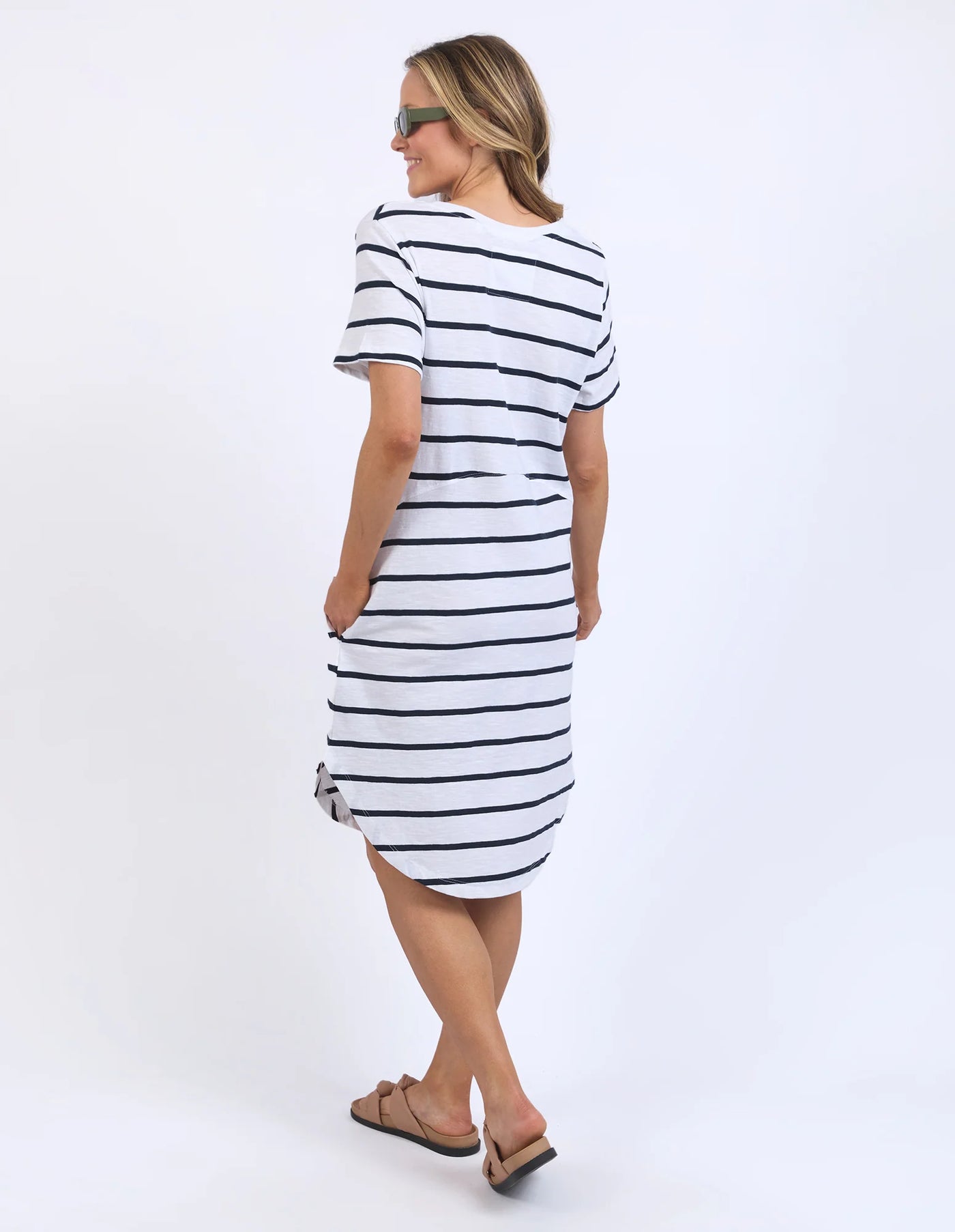 woman facing the back wearing sunglass, foxwood bay stripe dress in black white stripe and slip on slippers