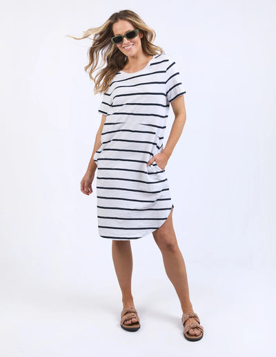 woman wearing sunglass, foxwood bay stripe dress in black white stripe, and slip on slippers