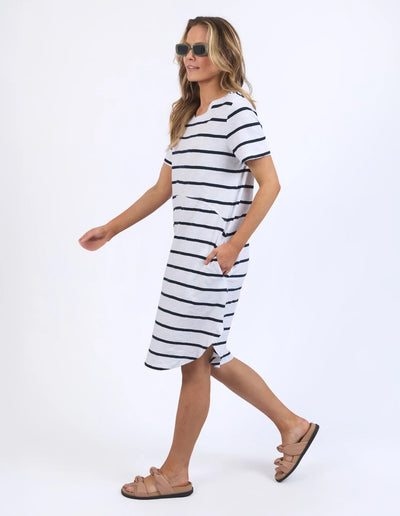 woman wearing sunglass, foxwood bay stripe dress in black white stripe, and slip on slippers