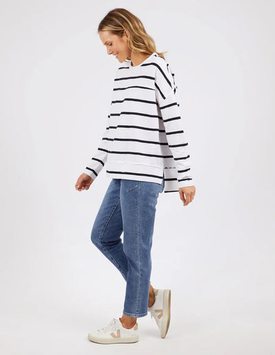 woman wearing denim pants and foxwood jayne stripe throw on top white dark  sapphire stripe and white shoes