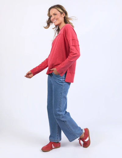 woman wearing foxwood jayne throw on top in cayenne red, denim parents, and red shoes