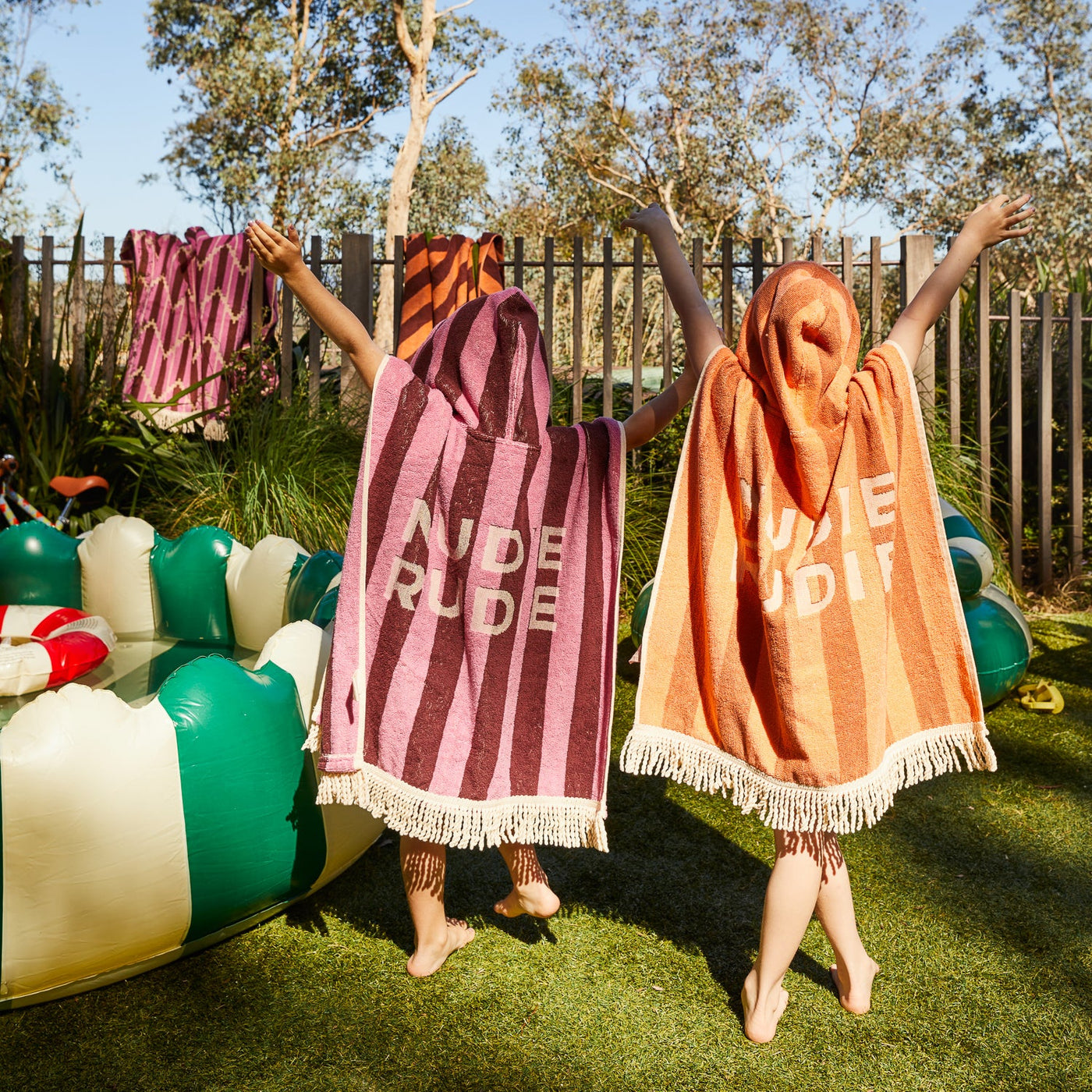 two kids wearing sage clare jarita hooded towel in roseway and desert colour